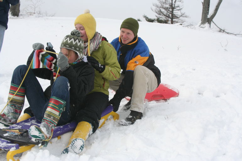 Nathan pushing Lucy and Annie down hill at Falling Creek Camp