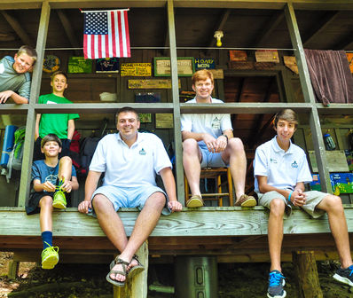 Campers and counselors gathered on a cabin porch.