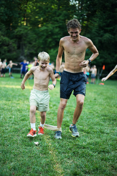 Camper and Counselor doing the 3-Legged Race at summer camp.