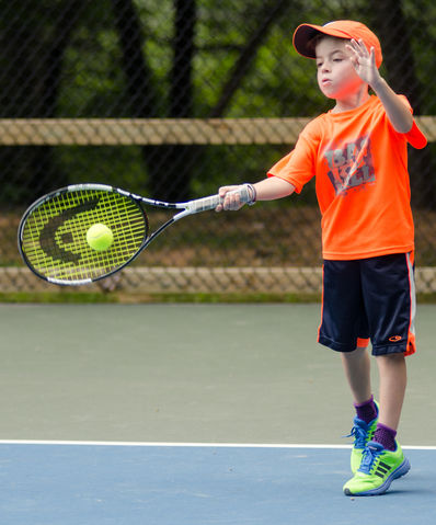 Camper playing a tennis match a camp.